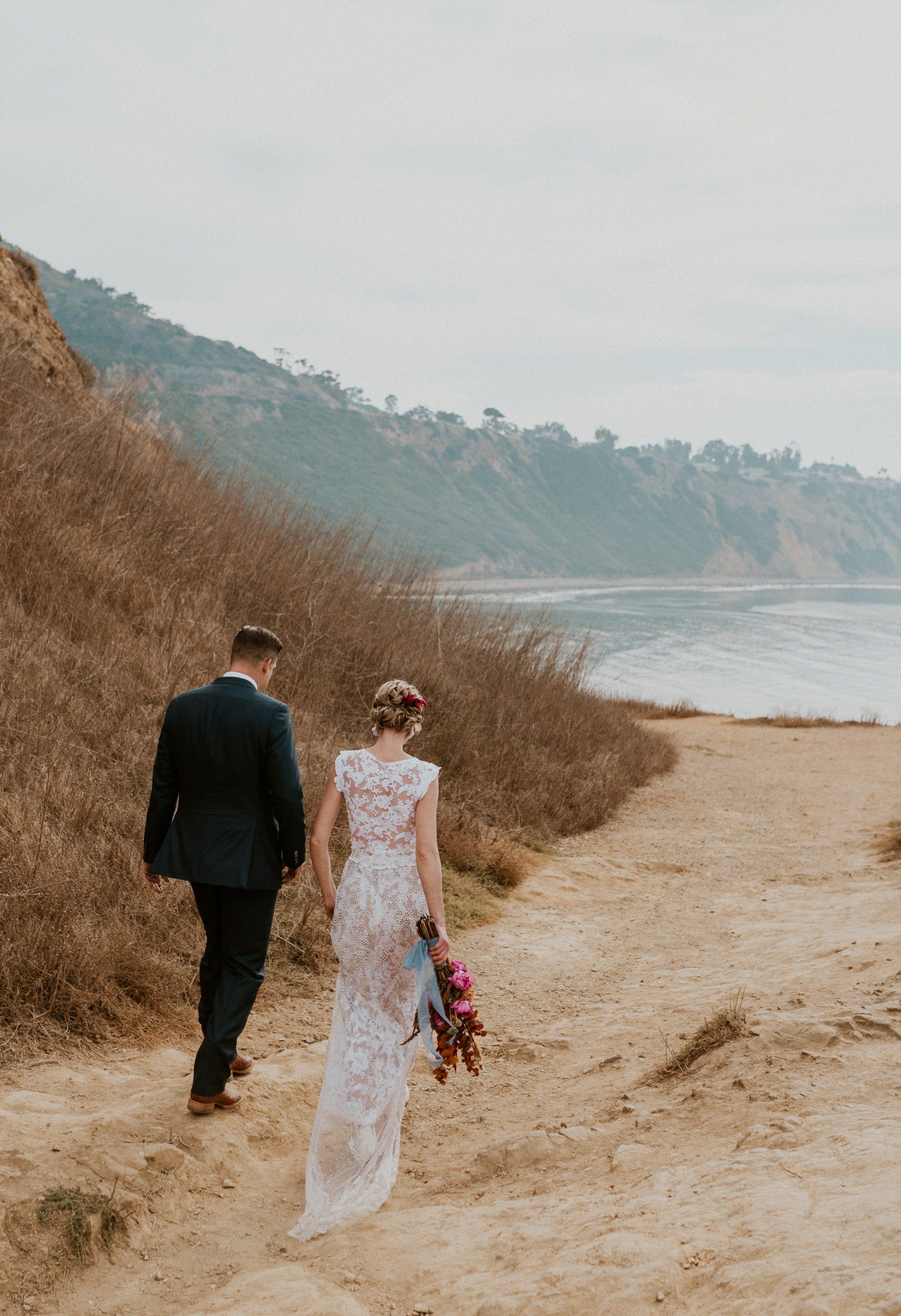 bride and groom by california coast